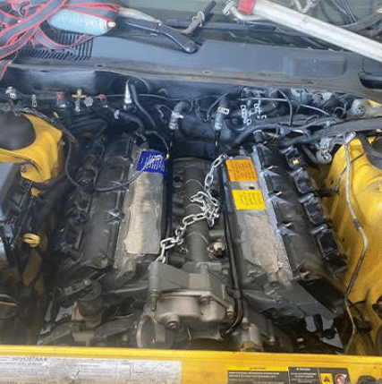 Yellow Dodge engine bay showing detailed engine work and component installation