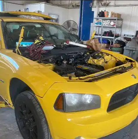 Yellow Dodge Charger engine bay during major engine replacement service