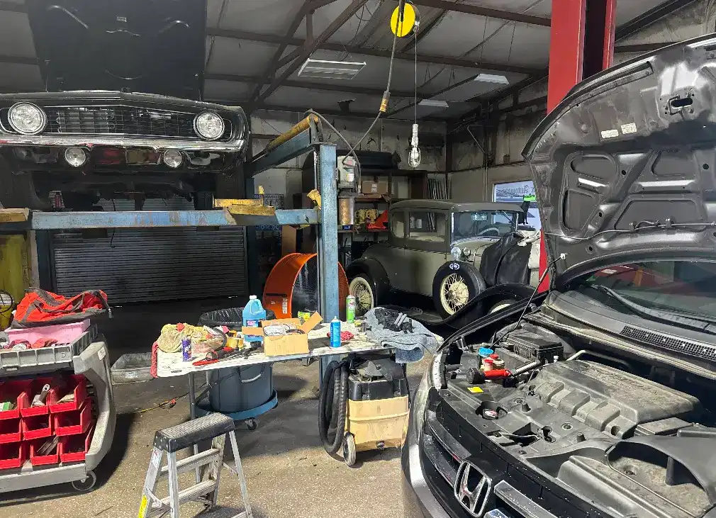 RJ Fox Automotive shop interior with classic cars and modern vehicles under repair