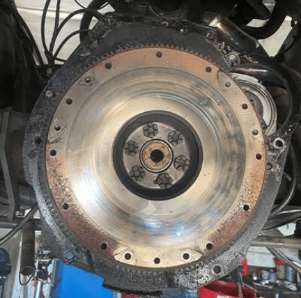 Close-up of transmission flywheel showing wear during automotive repair inspection